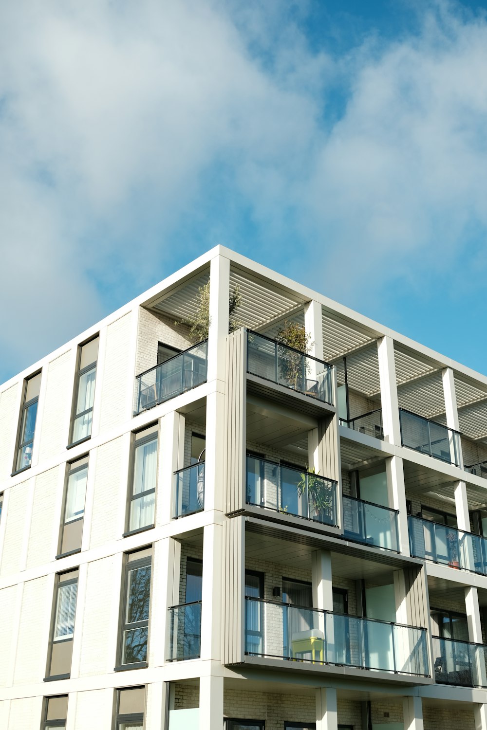 Modern apartment building with glass balconies against a blue sky